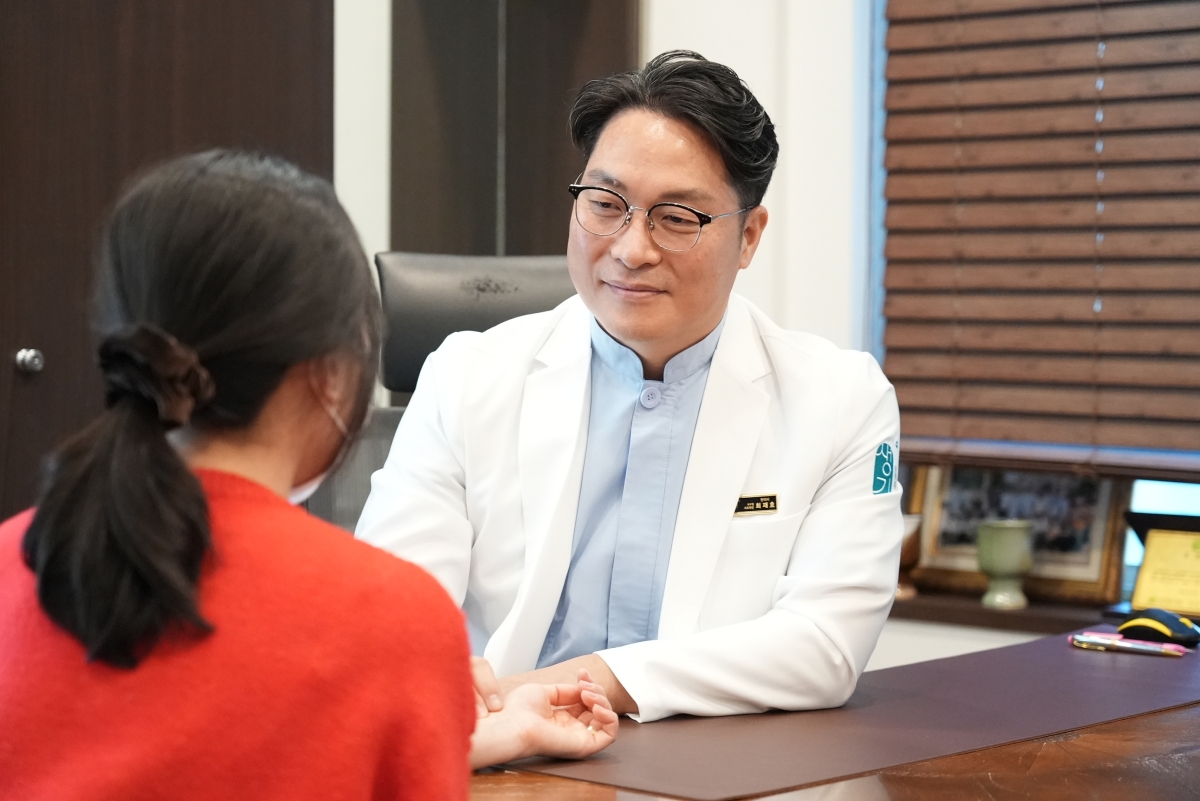 최재호 대표원장이 내원객과 마주 앉아 증상을 듣고 있습니다.